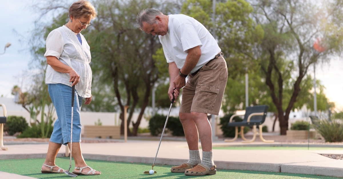 senior couple playing mini golf