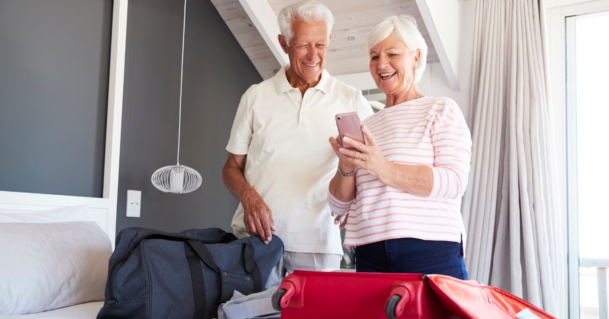 senior couple using smartphone on vacation