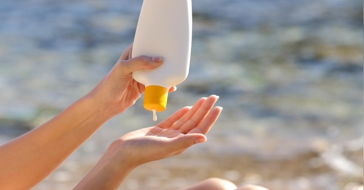woman applying sunscreen on beach