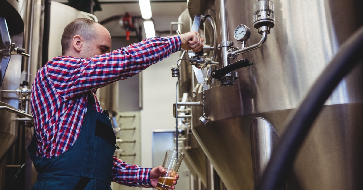 brewer filling beer from storage tank