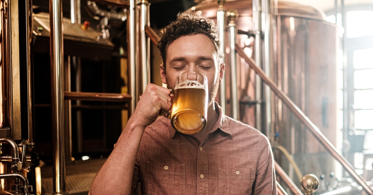 Man tasting fresh beer in brewery