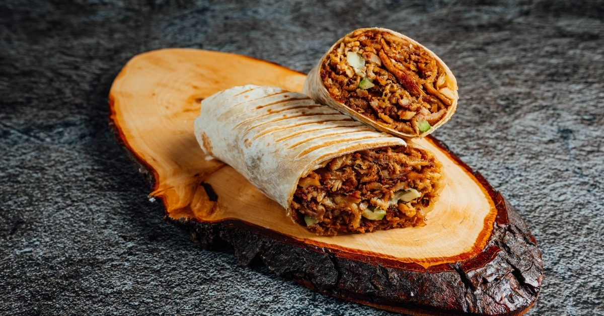 half burrito on wooden board