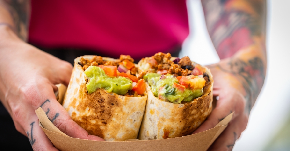 chef holding guacamole beef burritos