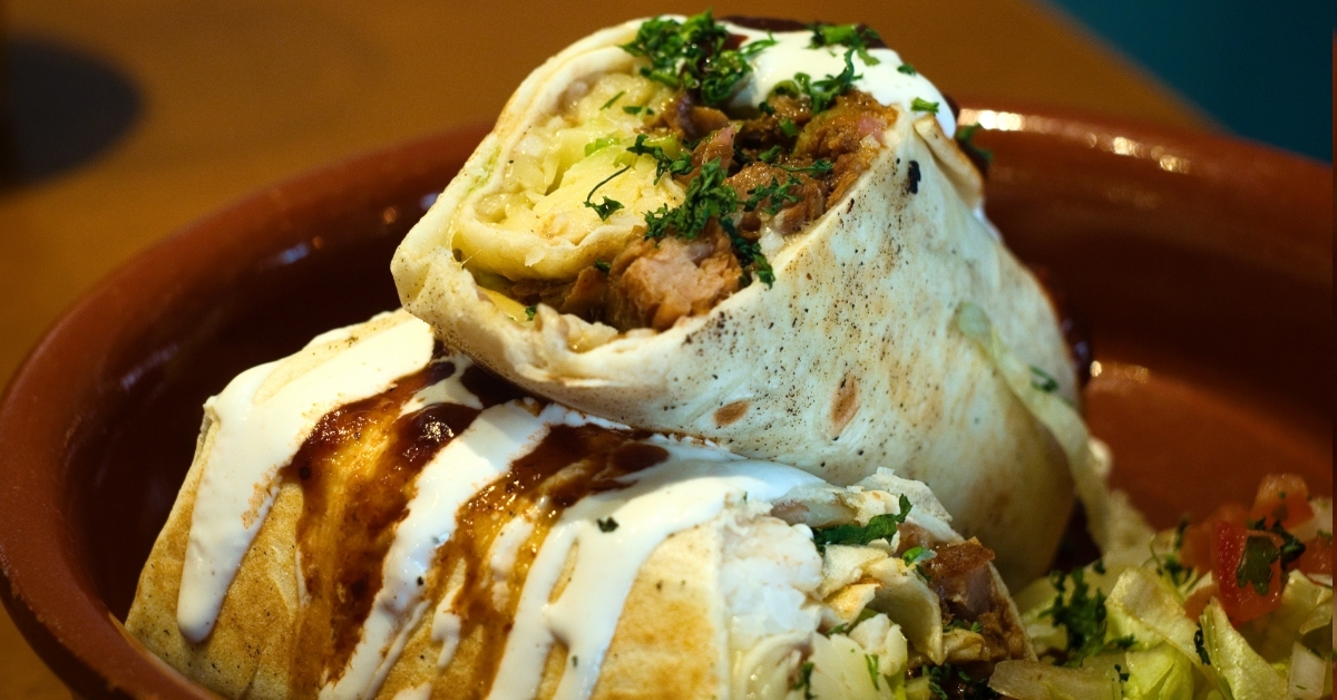 juicy burritos on plate with garnishing