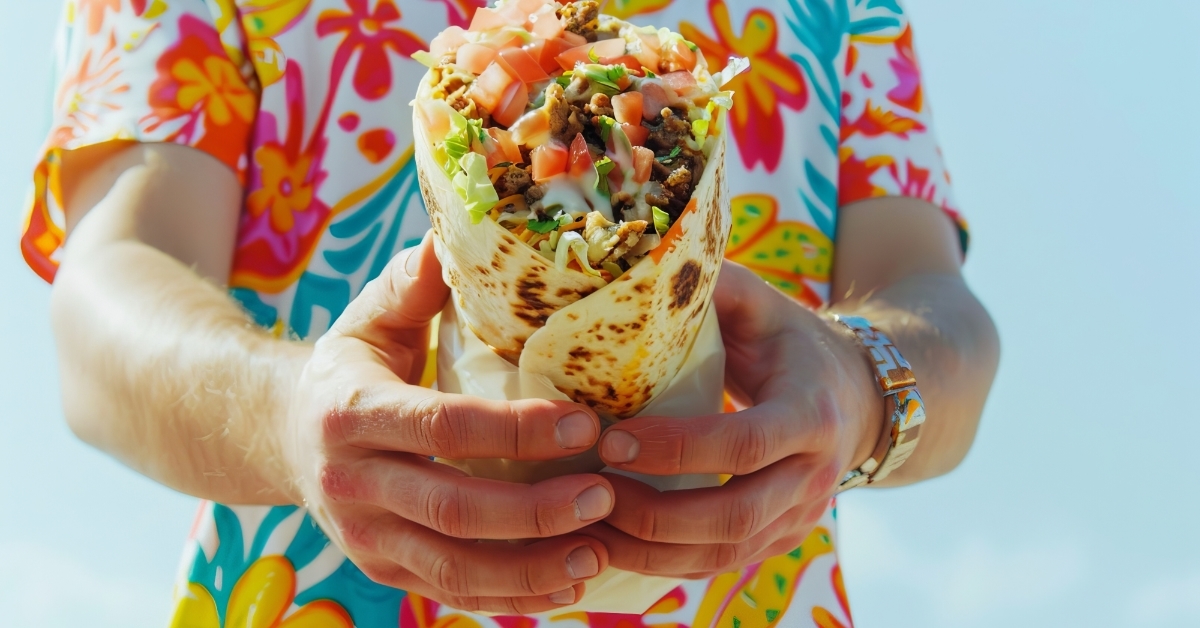 man in floral shirt holding burrito