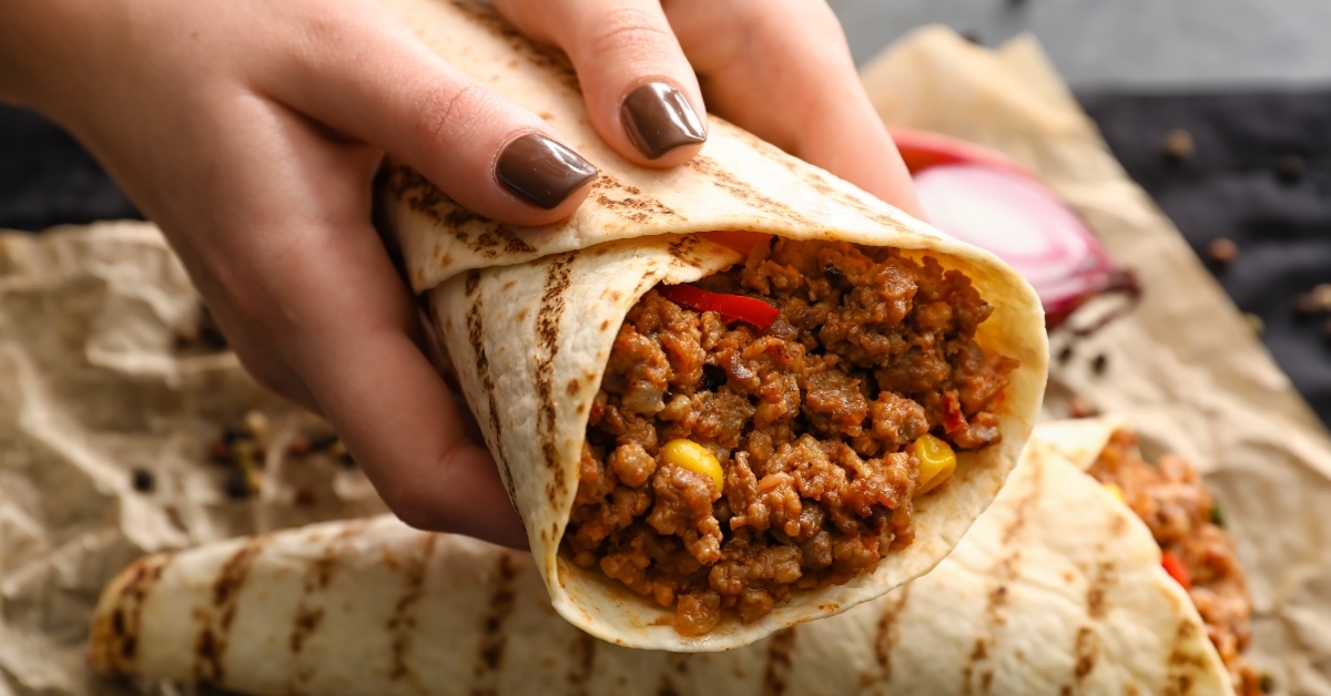 Woman holding tasty masala burrito