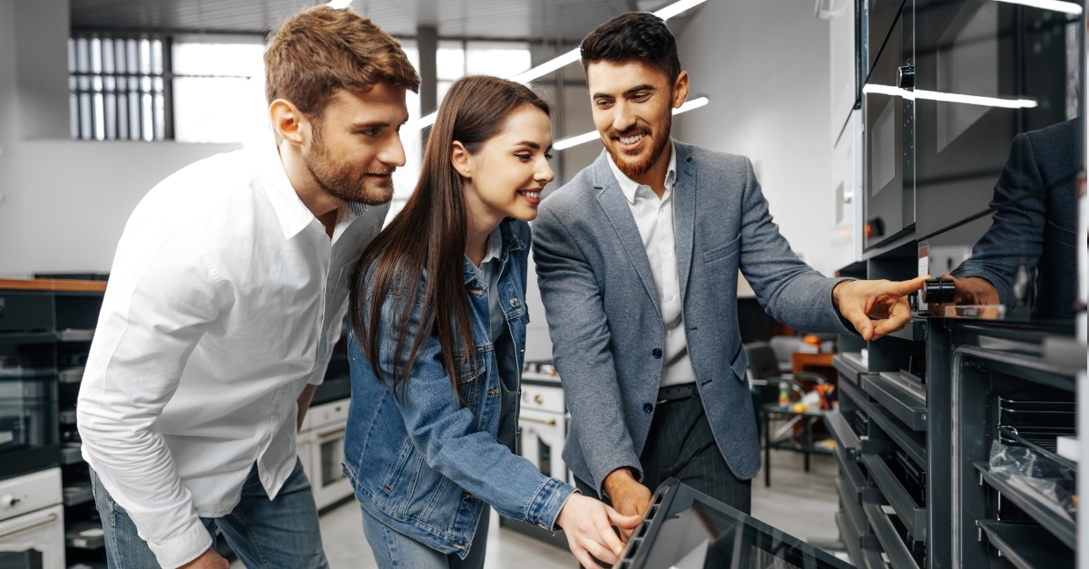 male salesman showing appliances to couple
