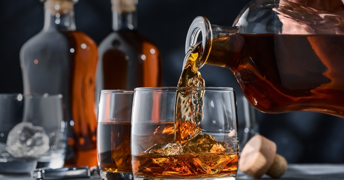 whiskey poured from glass bottle