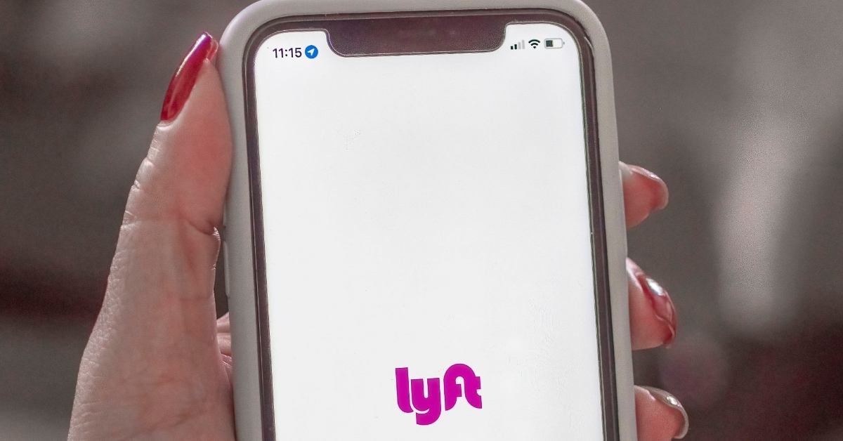 woman holding smartphone with lyft logo