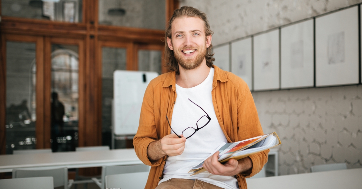 man sitting on desk with glasses