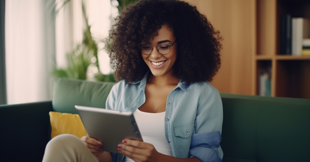 african woman reading book using tablet