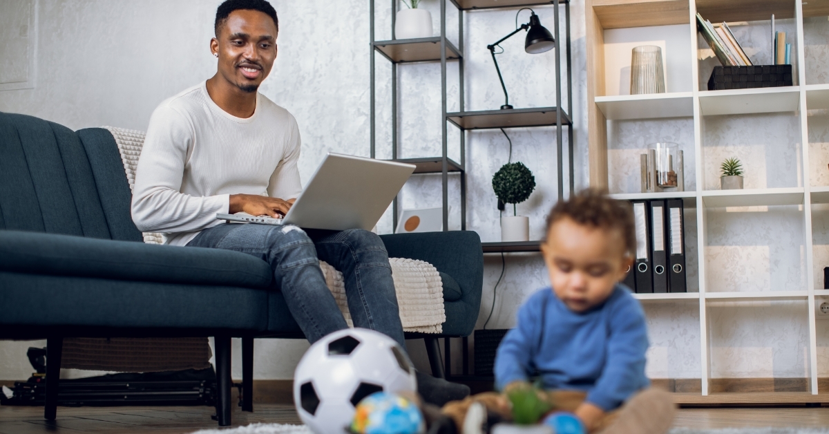 african father working remotely with baby