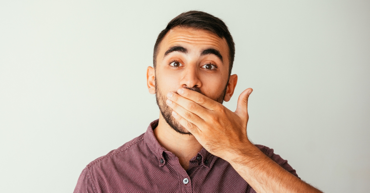 young man covering mouth