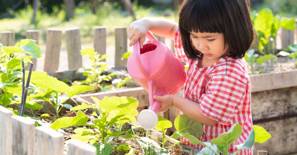 cute asian girl watering plants outdoor