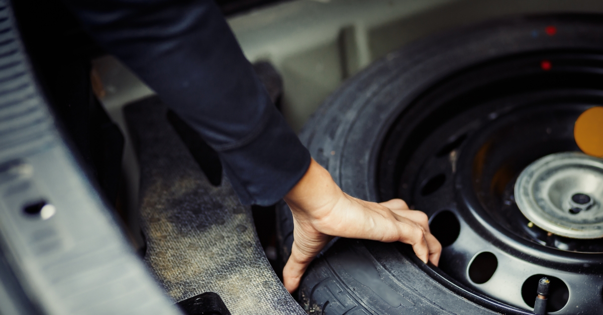 hand taking spare tire