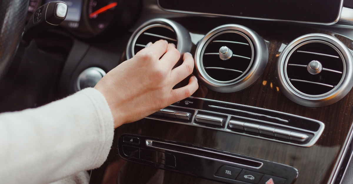 woman turning on car aircon