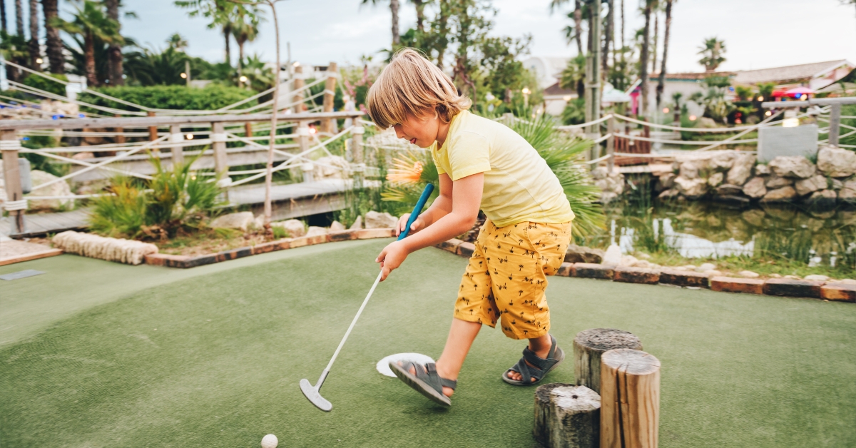 boy playing mini golf