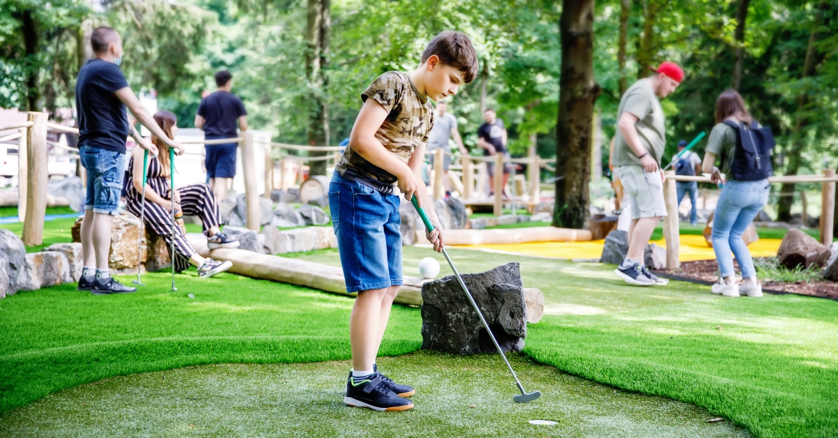 boy playing mini golf