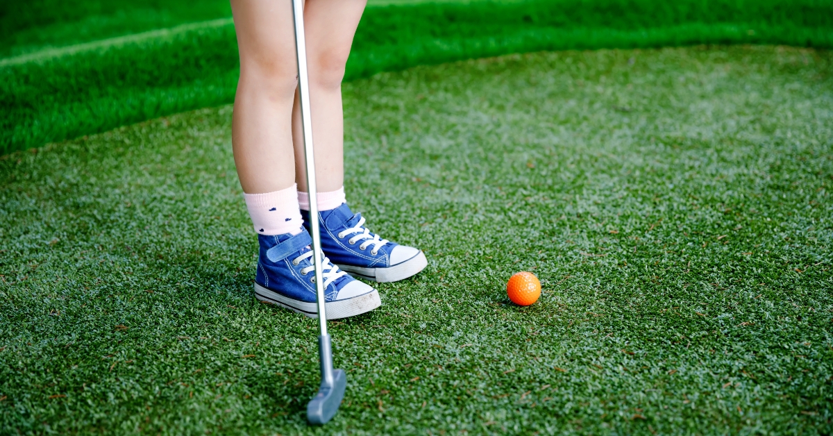 preschool girl playing mini golf
