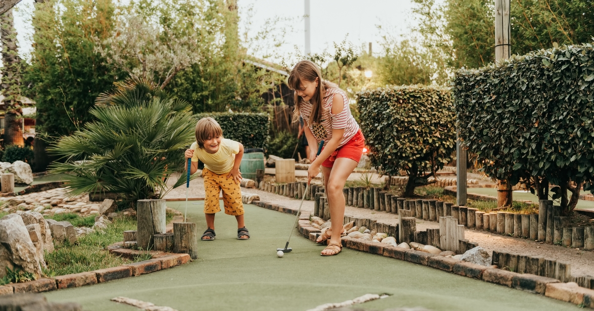 two kids playing mini golf