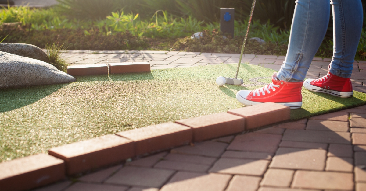 young woman plays mini golf