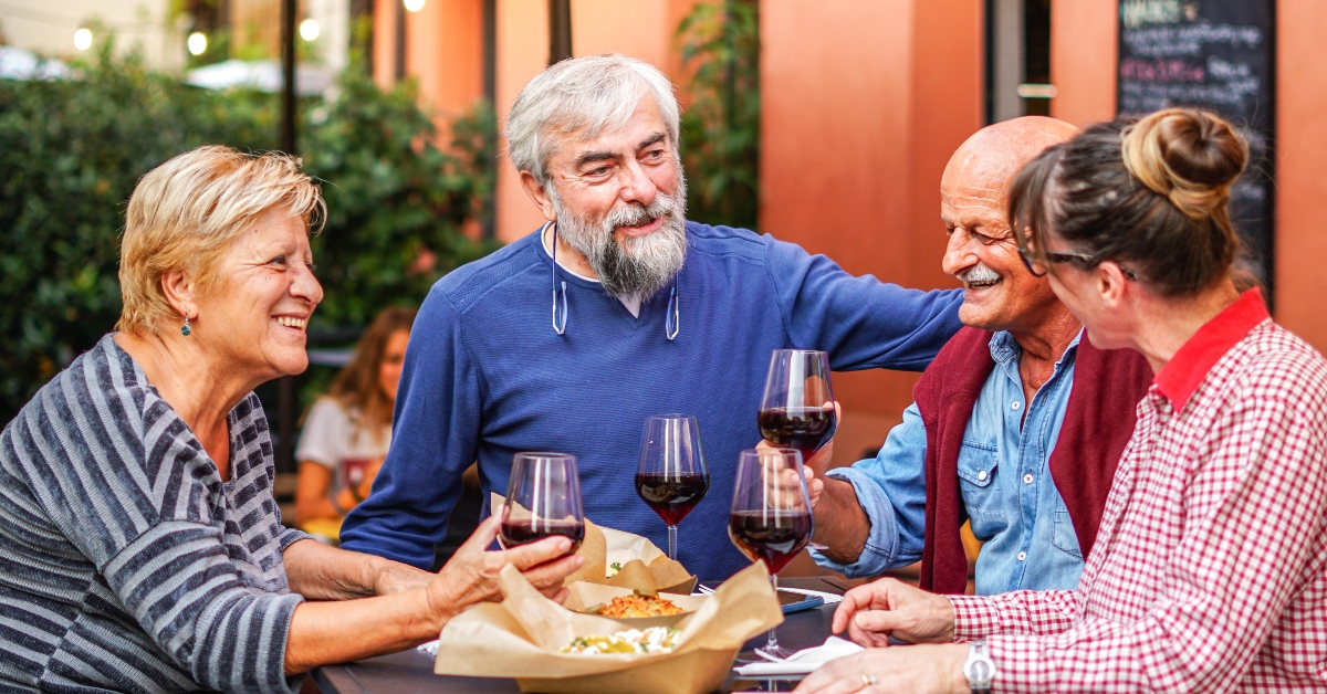 happy elderly friends drinking wine
