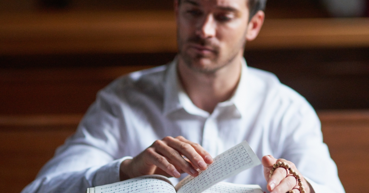 man worshipping holy book