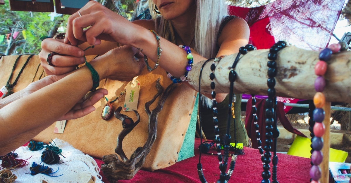 woman buying handmade jewelry from stall