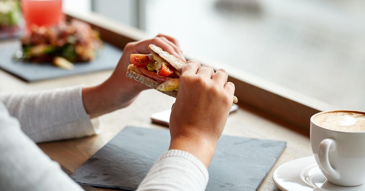 eating salmon panini sandwich