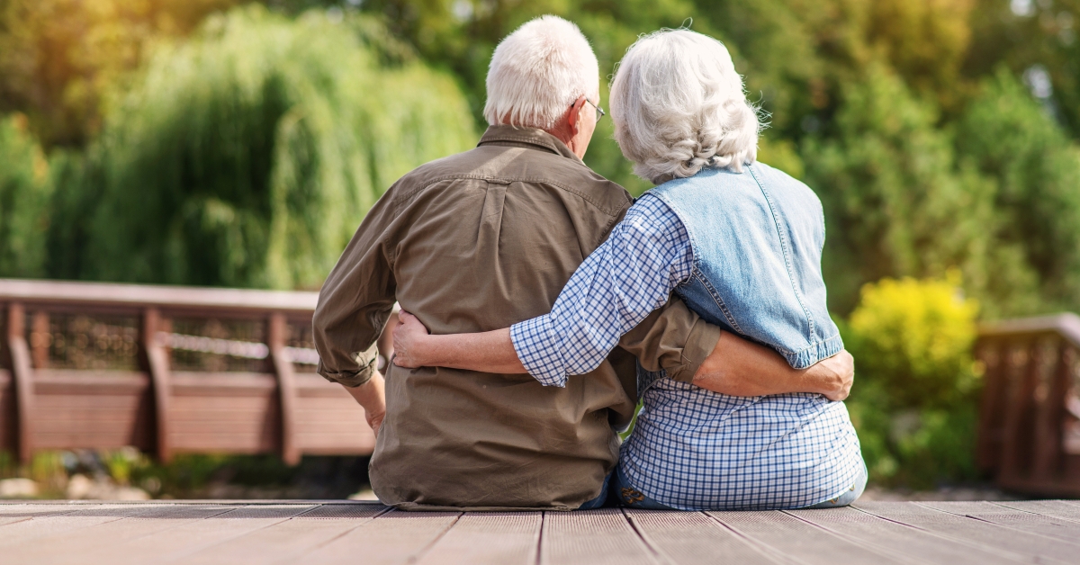 mature couple resting near lake