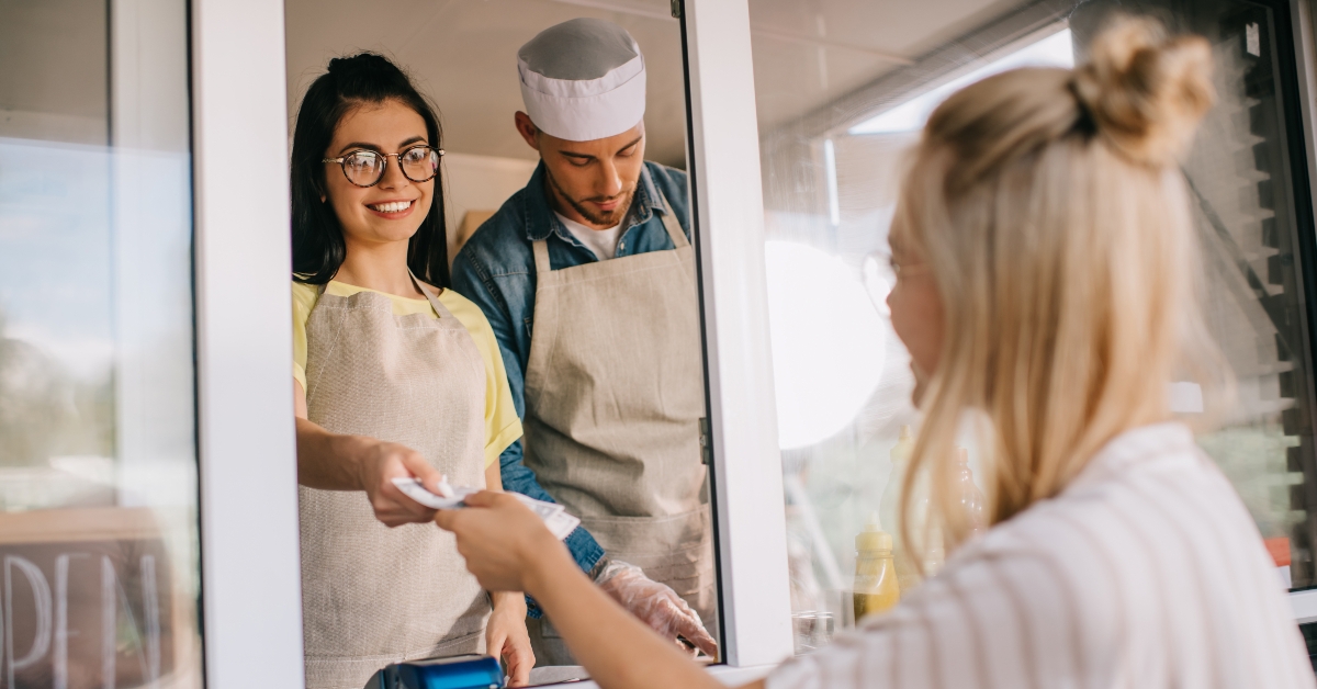 paying to smiling worker in food truck