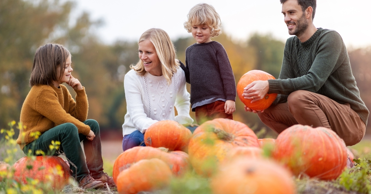 family in pumpkin patch field