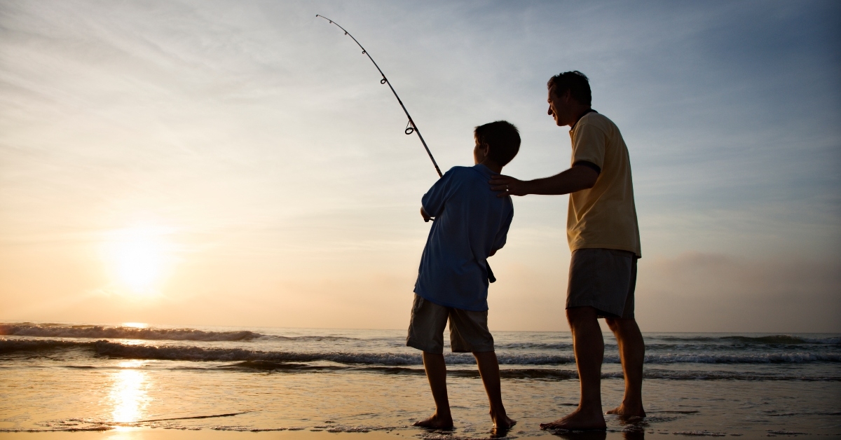 young boy fishing in surf