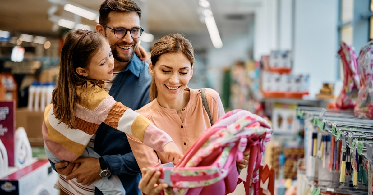 parents buying backpack for daughter