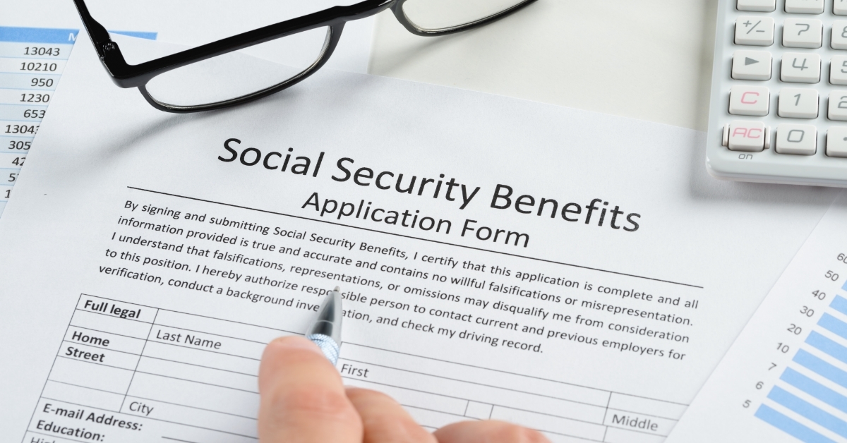 hand filling Social Security Benefits Form