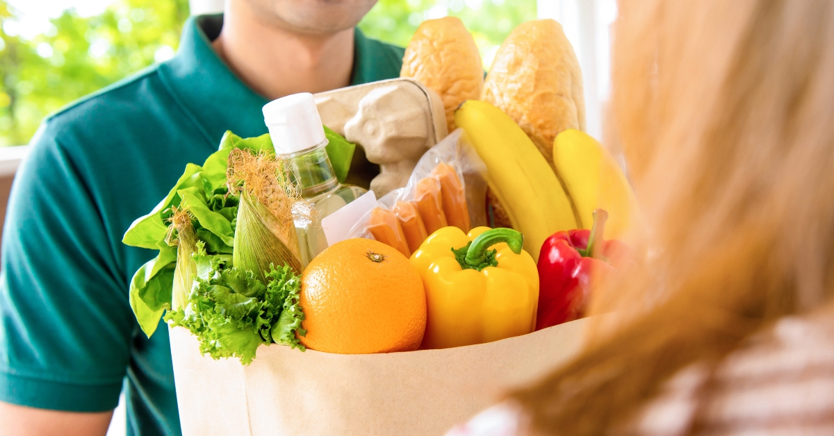delivery man giving grocery bag