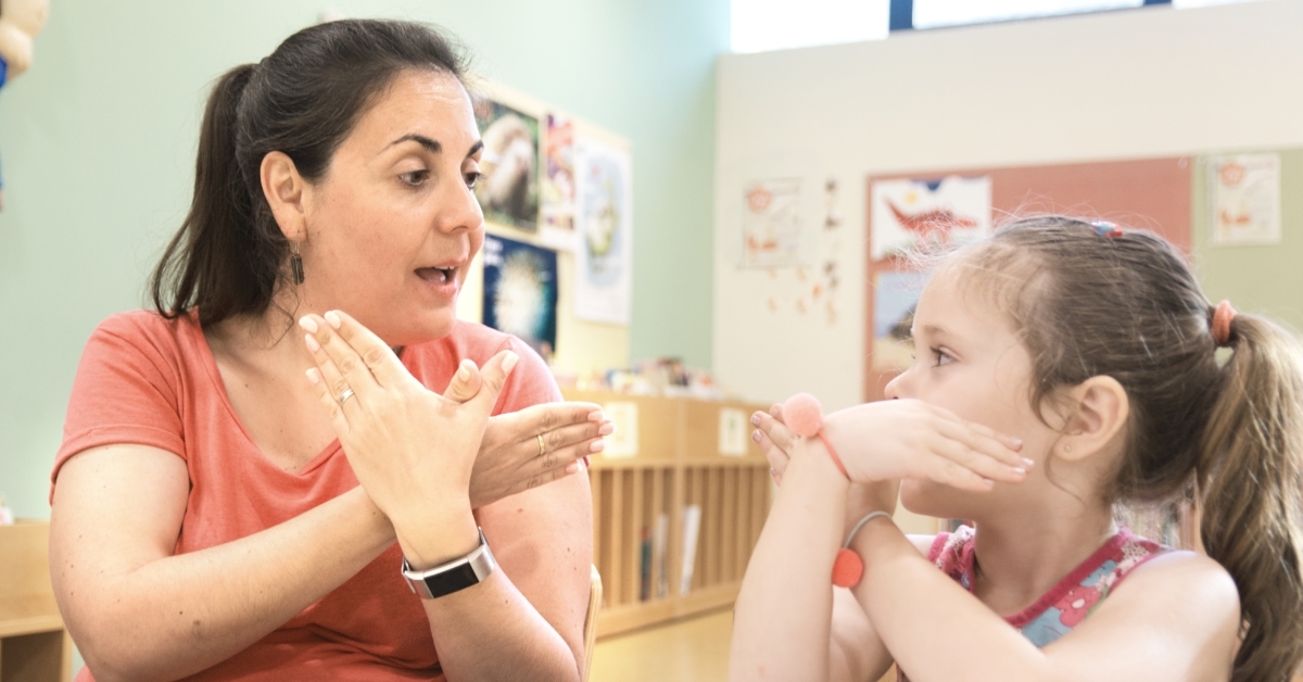 sign language teacher tutoring little girl