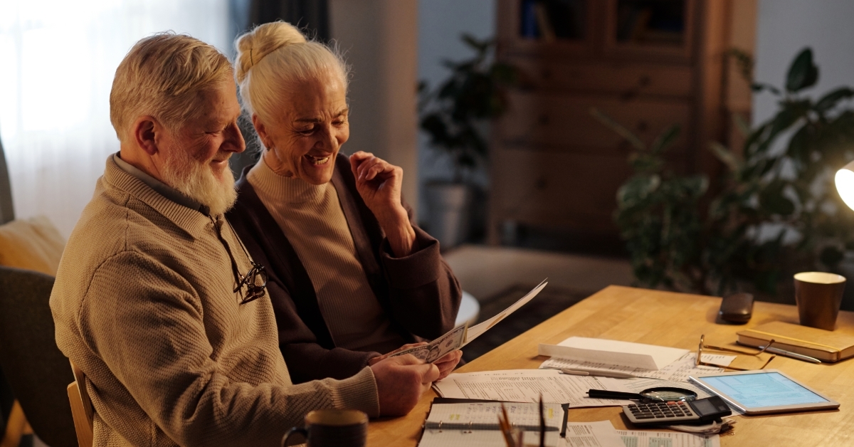 excited senior couple reading letter 