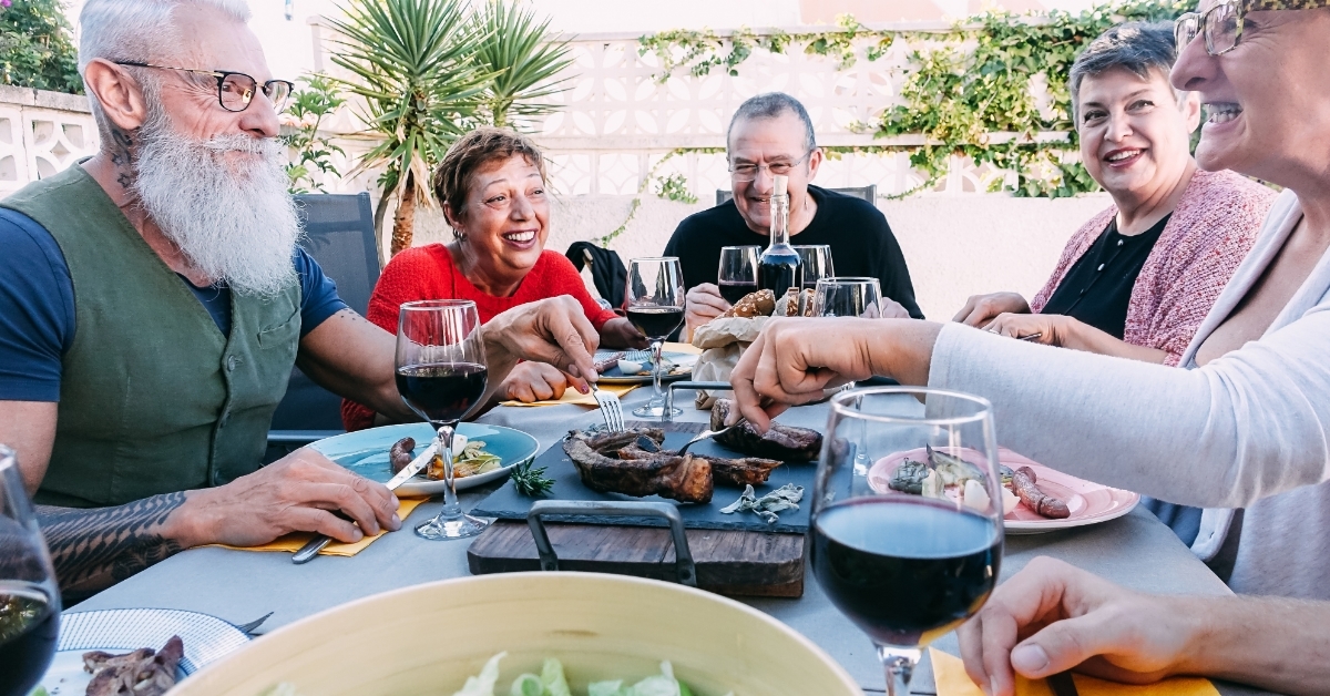 senior friends eating at backyard party