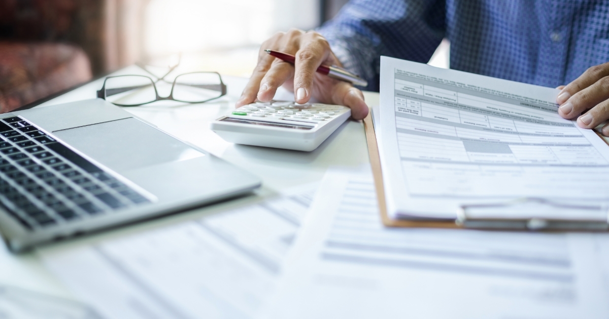 stressed man calculating monthly expenses