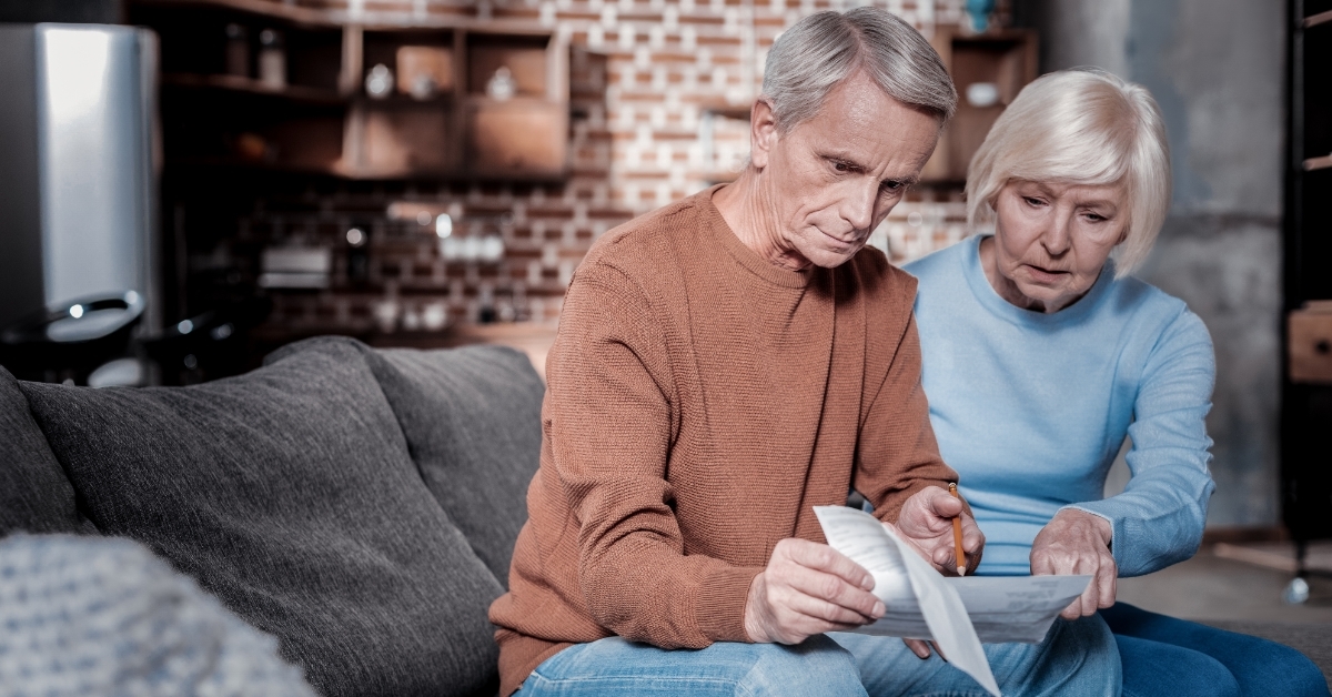 angry senior couple reviewing bills together