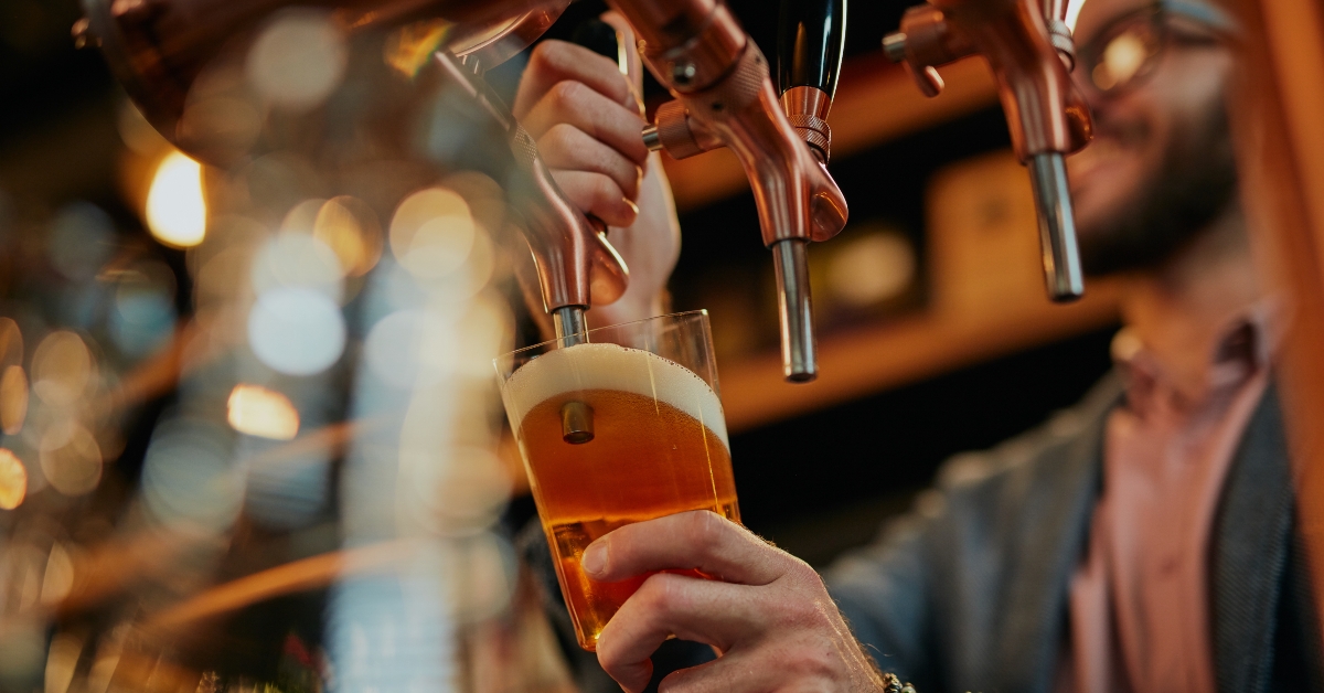 Barman pouring beer while standing