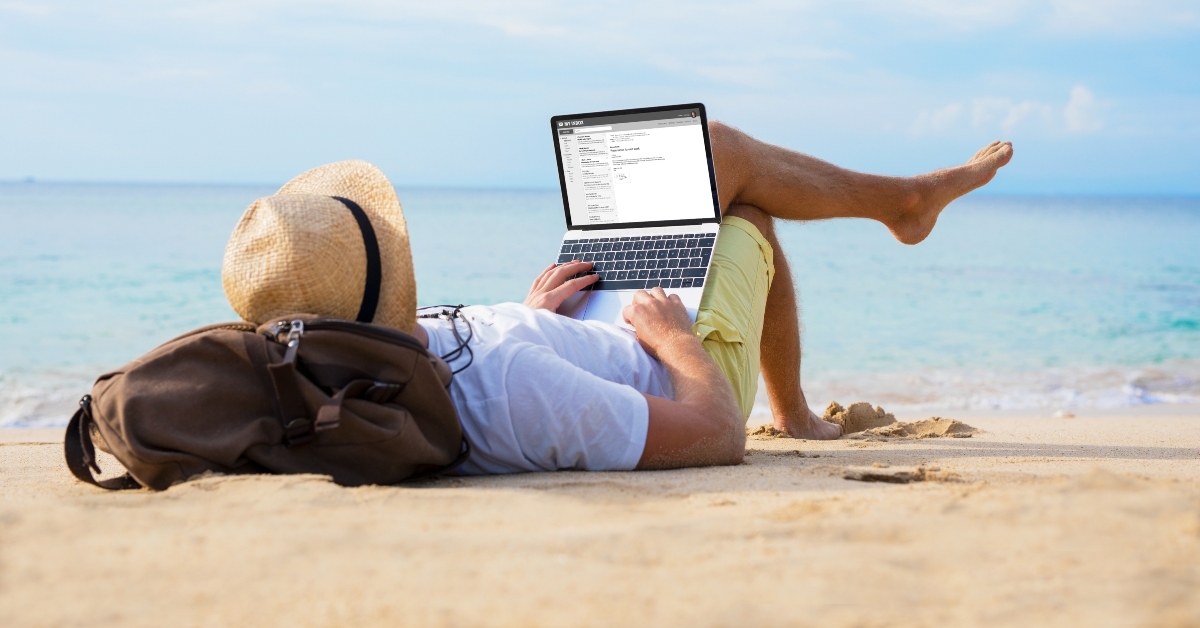 on laptop while relaxing on beach