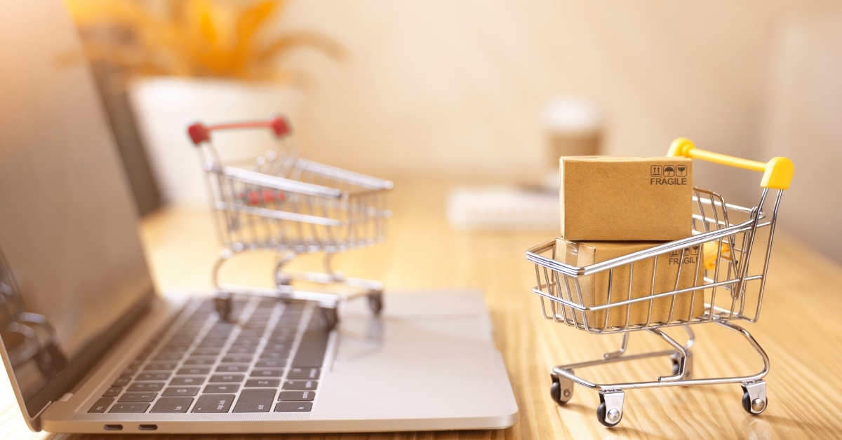 miniature trolleys over laptop online shopping concept