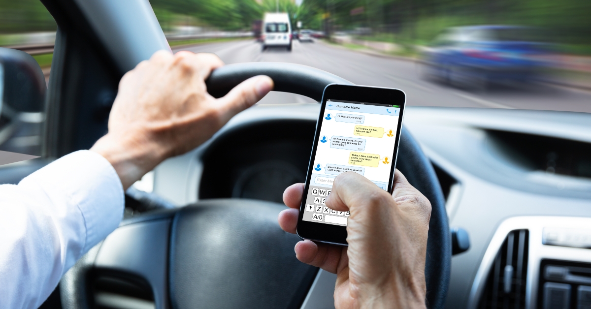 Man typing text while driving
