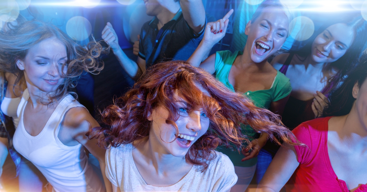 smiling friends dancing in club