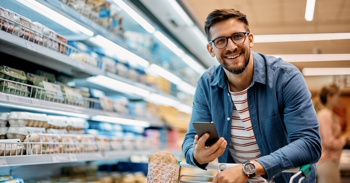 man using smartphone while doing grocery
