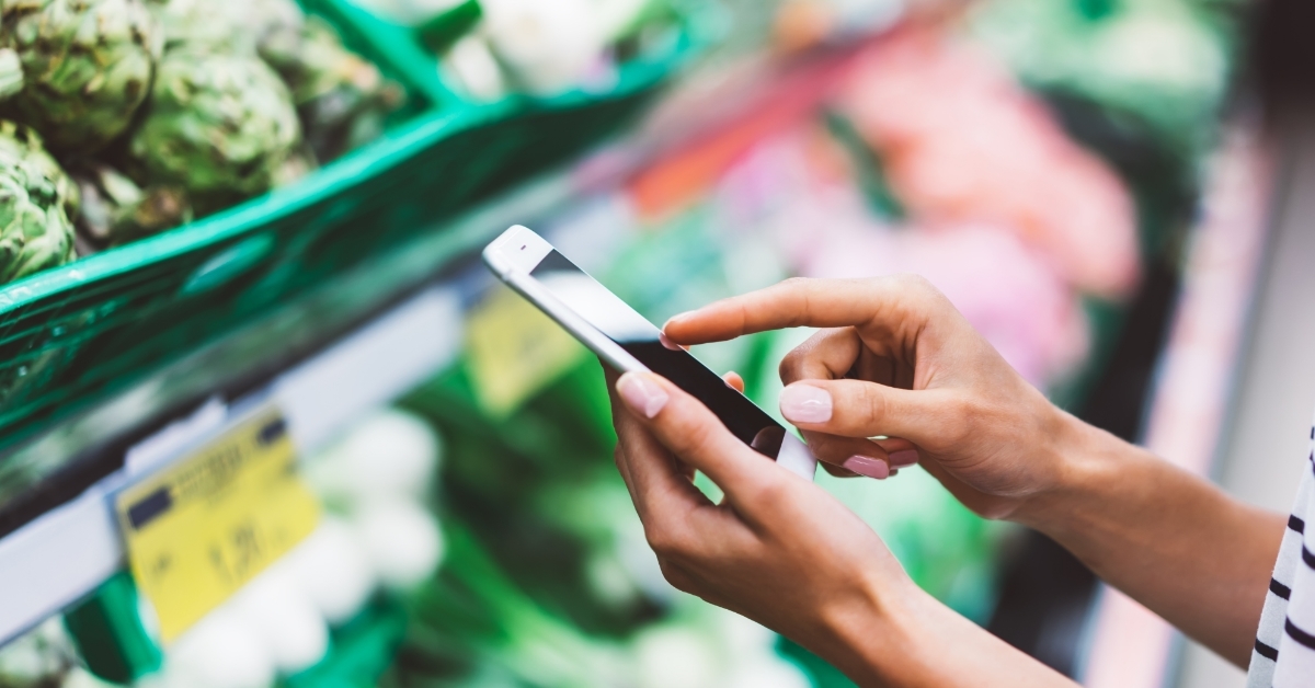 woman using smartphone at supermarket