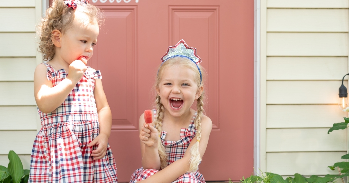 two little girls eating popsicles outdoor