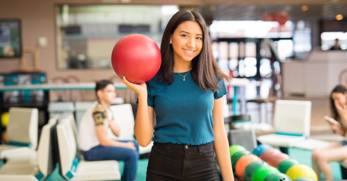 girl carrying red bowling ball